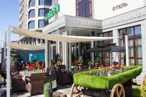 a restaurant with tables and chairs and an umbrella at Garden Hotel in Bishkek