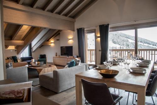 a living room with a dining table and a living room at Le C by Alpine Residences in Courchevel