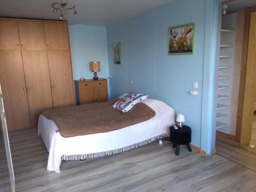 - une chambre avec un lit et un mur bleu dans l'établissement domaine de Castencau, à Saint-Louis-de-Montferrand