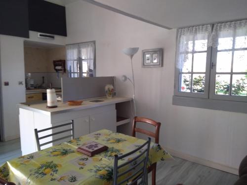 - une cuisine avec une table, une table et des chaises dans l'établissement domaine de Castencau, à Saint-Louis-de-Montferrand