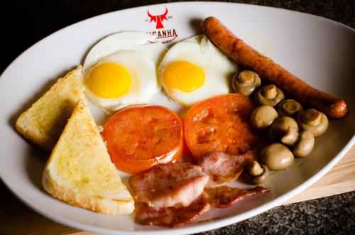 a plate of breakfast food with eggs sausage tomatoes and bread at Picanha Guesthouse in Heidelberg