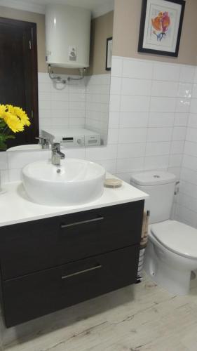 a bathroom with a sink and a toilet at Beachside Jablillo y Cucharas in Costa Teguise