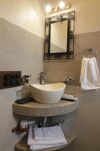 a bathroom with a white sink and a mirror at The Mandeville in Kolkata
