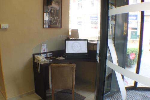 an office with a desk with a computer and a chair at ibis Besançon Centre Ville in Besançon