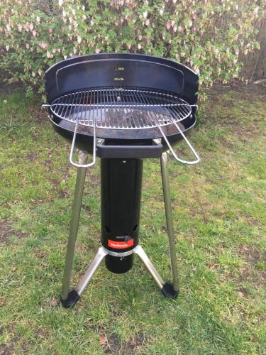 a grill sitting on the grass in the yard at Cottage Fleuri in Koksijde