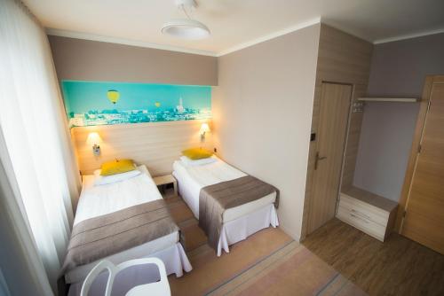 a hotel room with two beds and a view of the city at Hotel Cristal Białystok in Białystok