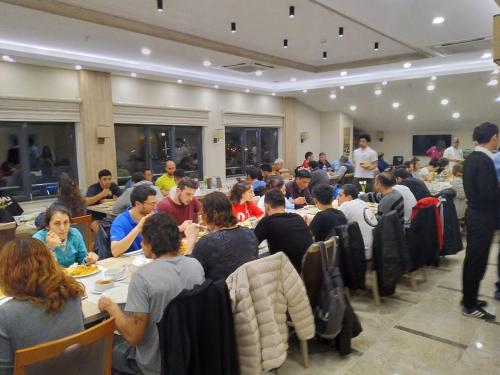 a group of people sitting at tables in a room at Oytun Park Hotel in Canakkale