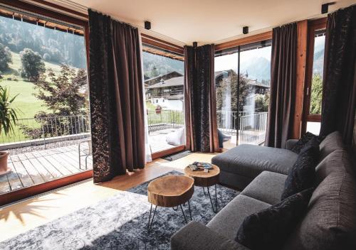 a living room with a couch and a large window at ACTIVE by Leitner's in Kaprun