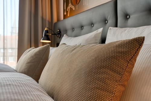 a bedroom with a bed with pillows on it at Centro Hotel Stern Ulm City, Trademark Collection by Wyndham in Ulm