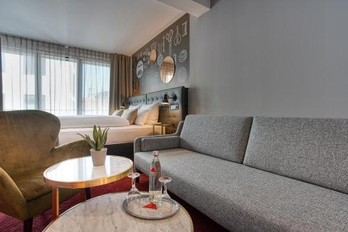 a living room with a couch and a table at Centro Hotel Stern Ulm City, Trademark Collection by Wyndham in Ulm