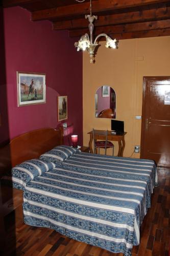 a bedroom with a large bed with a blue and white blanket at Hotel San Lorenzo in Florence