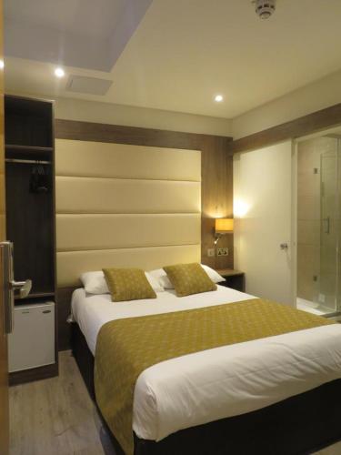 a hotel room with two beds and a bathroom at Glendale Hyde Park Hotel in London