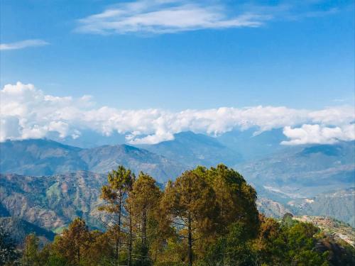 a view of a mountain range with trees in the foreground at Hotel At The End Of The Universe in Nagarkot