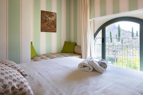 Tenuta Saiano Resort في Torriana: سرير عليه مناشف في غرفة مع نافذة