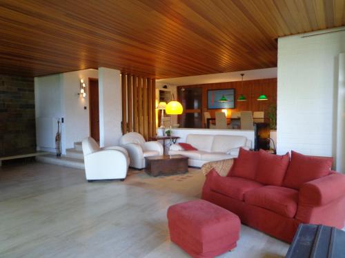 a living room with white furniture and a red couch at Green Hill Guest House and Apartment in Overijse