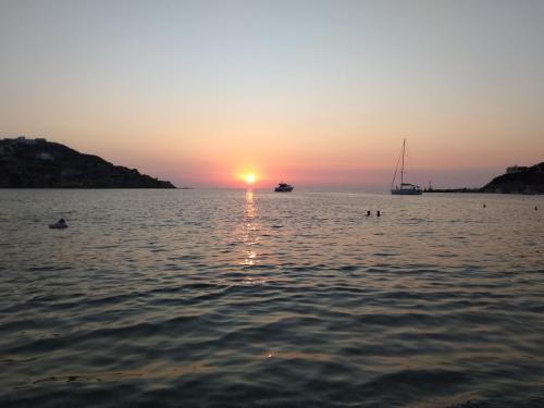 a sunset over a body of water with a boat at VILA INSPIRATION - ON KINI BEACH in Kinion