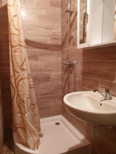 a bathroom with a shower curtain and a sink at Kontyos Vendégház in Felsőtold