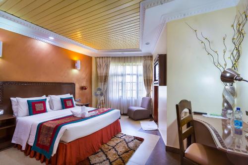 a hotel room with a large bed and a window at Comfort Gardens in Nairobi