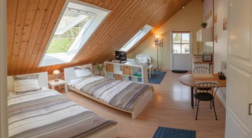 a attic room with two beds and a table at Domaine Beauregard in Rolle