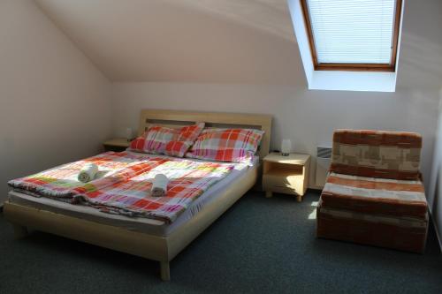 1 dormitorio pequeño con 1 cama y 1 silla en Apartmán V Podskalí en Hluboká nad Vltavou