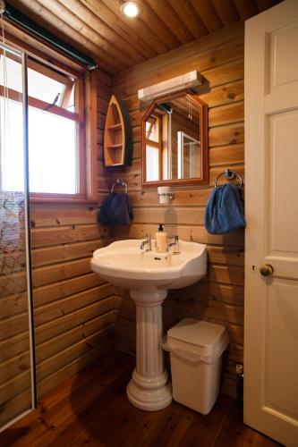 a bathroom with a sink and a mirror at Heatherbell Cottage Guest Accommodation in West Bay