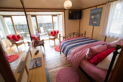 a bedroom with a bed and a couch at Heatherbell Cottage Guest Accommodation in West Bay