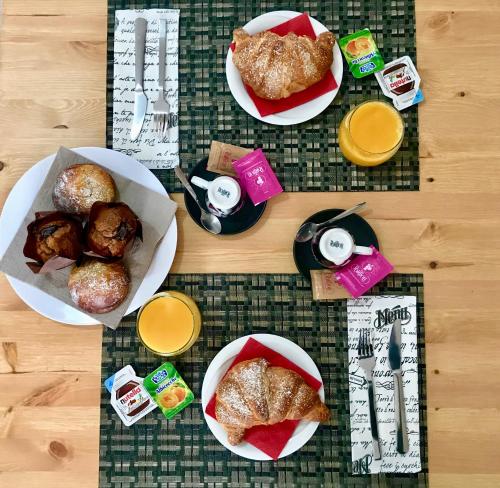 a table topped with plates of pastries and orange juice at Villa Paestum in Paestum
