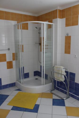 y baño con ducha y silla. en Apartmán V Podskalí en Hluboká nad Vltavou
