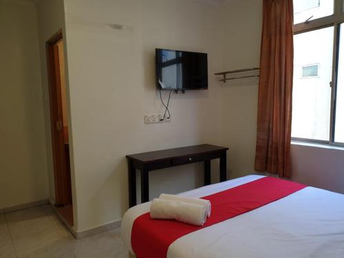 a bedroom with a bed and a tv on the wall at Fully Hotel Desa Tebrau in Johor Bahru
