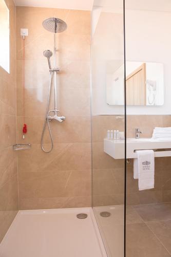 a bathroom with a shower and a sink at Mafra Hotel in Mafra