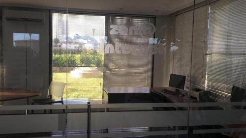 an office with a desk with a computer and a window at Parquemar Center PRIMERA LINEA FRENTE AL MAR Piso 8 LOS DEDOS Garage y amenities in Punta del Este