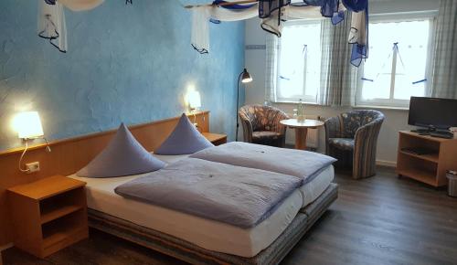 a bedroom with a bed and a table and chairs at Wirtshaus & Pension "Zum Hammer" in Neustadt