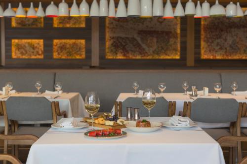 a table with glasses of wine and food on it at Marco Polo Hotel Gudauri in Gudauri