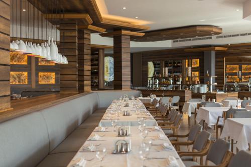 une salle à manger avec des tables et des chaises blanches dans l'établissement Marco Polo Hotel Gudauri, à Goudaouri