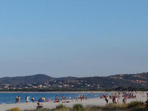 a group of people on a beach near the water at Sa Marina in La Caletta
