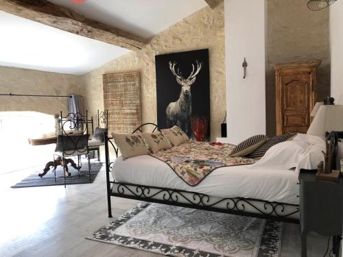 Schlafzimmer mit einem Bett mit einem Bild eines Hirsches an der Wand in der Unterkunft L'Ilot Vignes in Rauzan