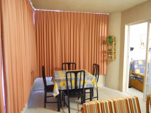 - une salle à manger avec une table, des chaises et un berceau dans l'établissement San Francisco - Fincas Arena, à Benidorm