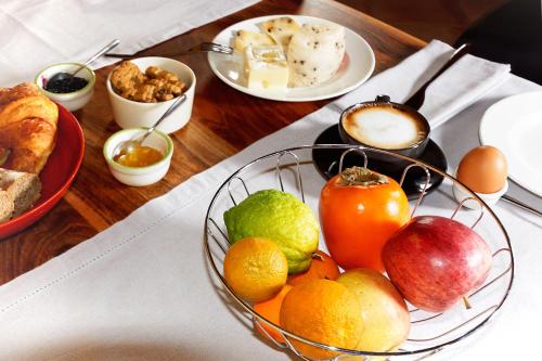 a wooden table with a bowl of fruit and other foods at Bed & Breakfast Bel Giorgio in Orentano