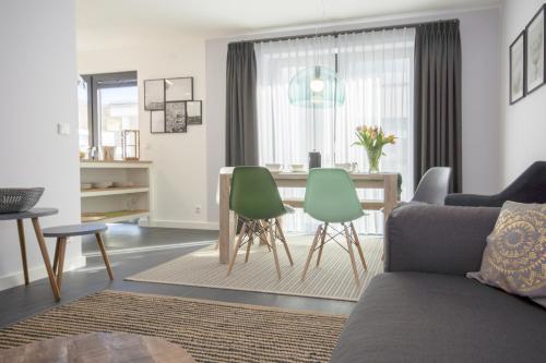 ein Wohnzimmer mit einem Sofa, einem Tisch und Stühlen in der Unterkunft Südstrandquartier - Ferienwohnung Cor in Ostseebad Sellin