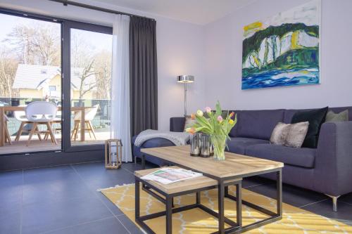 uma sala de estar com um sofá e uma mesa em Südstrandquartier - Ferienwohnung Loft em Ostseebad Sellin