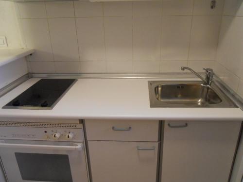 une cuisine blanche avec un évier et une cuisinière dans l'établissement San Francisco - Fincas Arena, à Benidorm