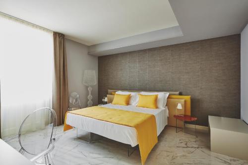 a bedroom with a large bed with yellow pillows at Palazzo Marletta Luxury House Hotel in Catania