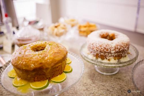 two donuts are sitting on plates on a table at Tonello Business Hotel in Campo Mourão