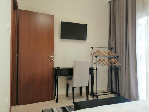 een slaapkamer met een bureau, een stoel en een televisie bij Luxurious Apartment in Veria