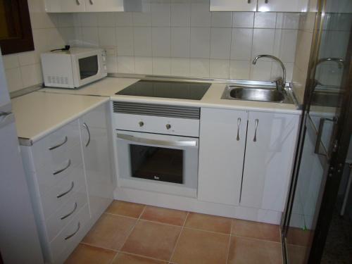 uma pequena cozinha com um lavatório e um micro-ondas em Islandia - Fincas Arena em Benidorm