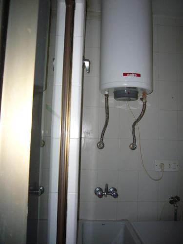 a bathroom with a shower and a sink and a tank at Islandia - Fincas Arena in Benidorm