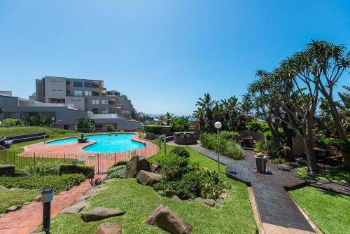 a swimming pool in a park with a building at The Boulders 304 in Ballito