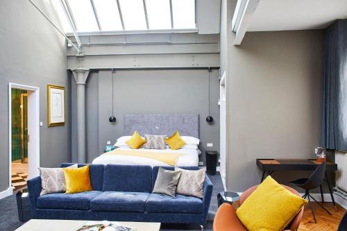 a bedroom with a bed and a blue couch at ABode Manchester in Manchester