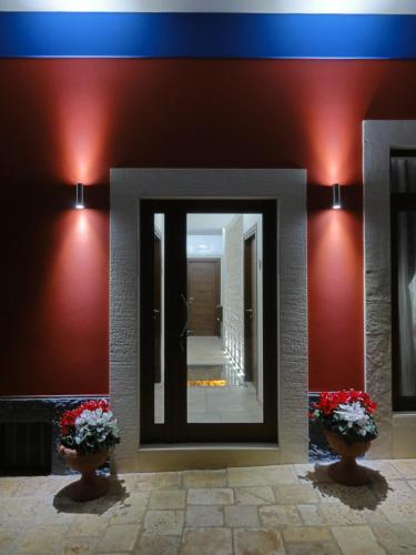 a mirror on a wall with two vases with flowers at Ape Rossa in Castellana Grotte