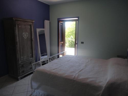 a bedroom with a bed and a door to a yard at Myricae in Farigliano